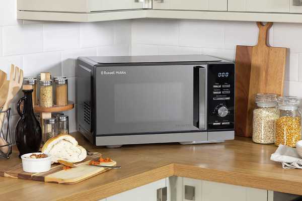 A Russell Hobbs 900W inverter microwave on a wooden kitchen top.
